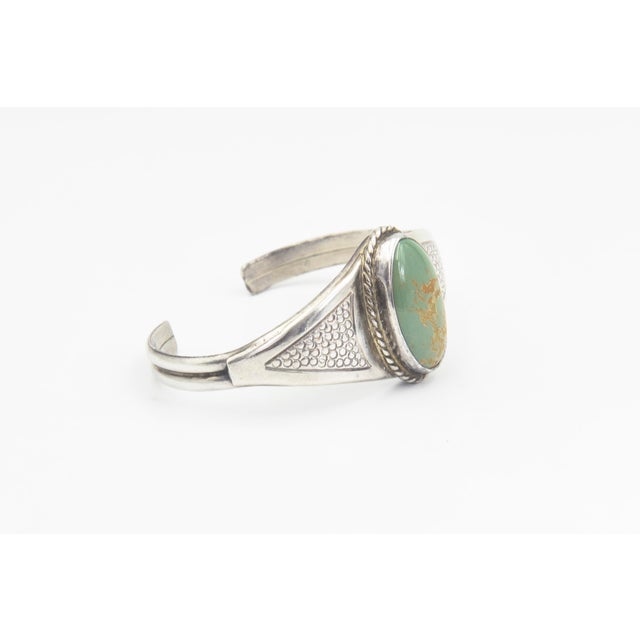 Southwestern Sterling Silver and Turquoise Cuff Bracelet A striking Southwestern sterling silver cuff bracelet featuring...