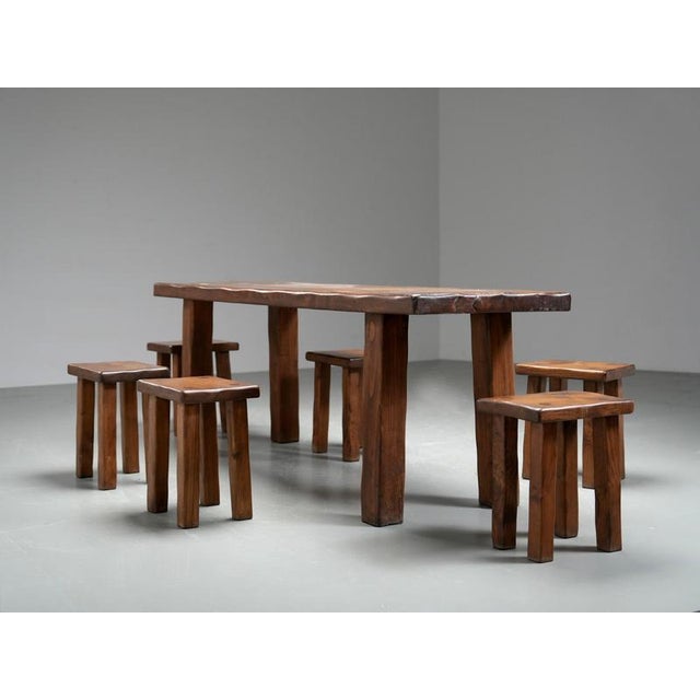 Large mid-century brutalist dining table with matching stools in solid pine, Europe, 1970s, in the style of Pierre Chapo....