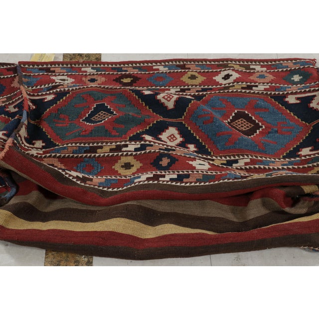 Handwoven in wool circa 1920-1930, this 2x9 Kilim is an antique Russian bag—a collectible textile once used by nomadic...