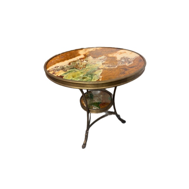Vintage two-tier round side table featuring beautifully figured natural onyx set within a brass-tone metal frame. The...