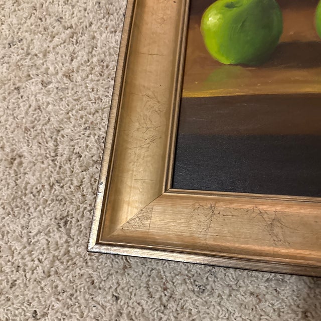 Contemporary original oil on canvas depicting three green apples on a table in a custom frame signed by artist. M McCay.