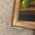 Contemporary original oil on canvas depicting three green apples on a table in a custom frame signed by artist. M McCay.