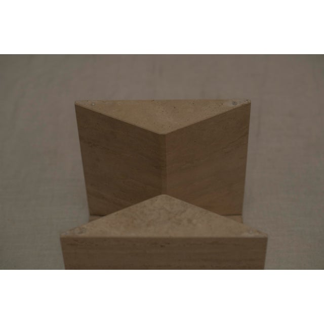 A sculptural Italian mid-century coffee or side table from the 1970s, featuring a solid travertine base paired with a...