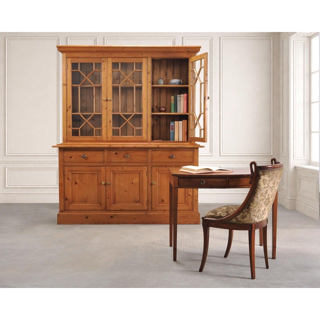 A handsome 20th century Georgian style country English pine bookcase cabinet featuring astral glazed glass doors....