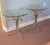 A pair of fine guilt metal Italian Hollywood Regency end tables with glass tops. Each features branches of Palm leaves in...