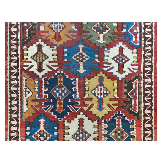 A rare and stunning early 20th century Persian Kuba kilim rug with a striking large-scale muli-colored stylized floral...