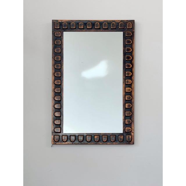 A mid century hammered copper wall mirror. Raised pattern with dark patinated surface.