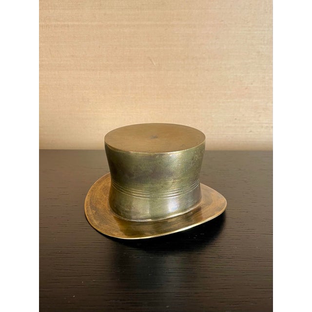 A refined vintage brass wine champagne coaster / holder in the form of a classic top hat, balancing sculptural charm with...