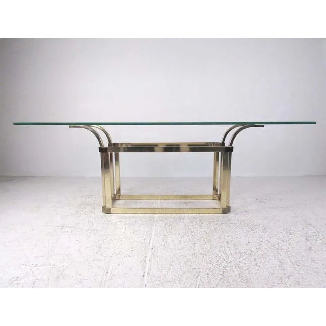 This oversized vintage brass sofa table features a midcentury-style brass base with a thick beveled glass top. Dimensions:...