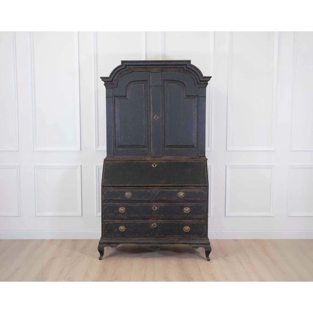 A beautiful 18th century Scandinavian bureau featuring a dramatic black painted finish and refined architectural...