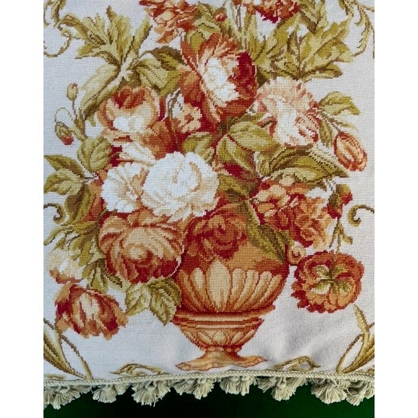 A beautiful vintage needlepoint pillow, that features a floral arrangement of roses and flowers in a classic urn vase,...
