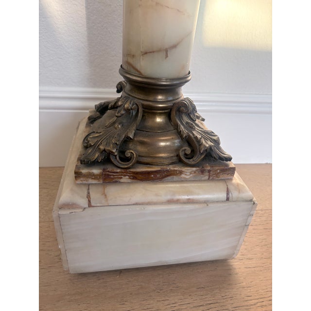 Elegant vintage Neoclassical pedestal crafted from richly figured cream and blush-toned onyx or stone, accented with...