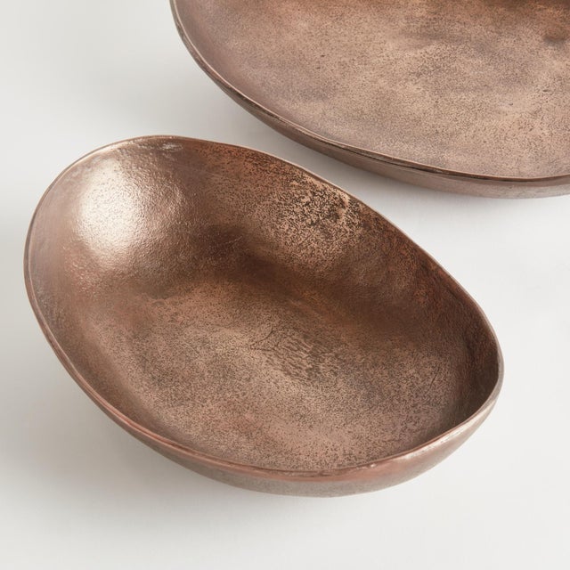 This pair of handcrafted bowls has simple oval silhouettes, with a copper finish and subtle texture. They can be styled...