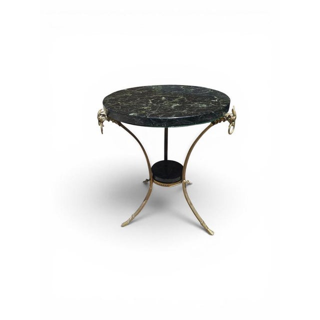 Elegant French Empire-style side table dating from the 1970s, featuring a richly decorated gilt bronze base and a...
