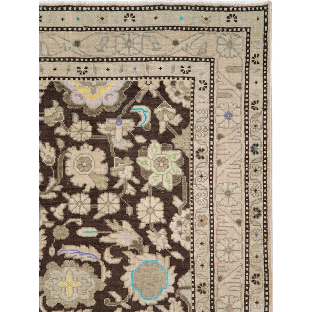 This mid-20th-century Persian Malayer rug presents a richly developed floral composition across a deep brown field. Large...