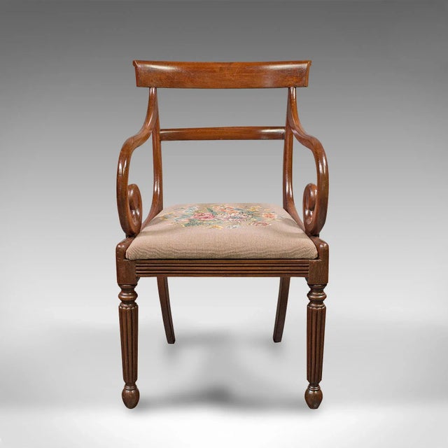 This is an antique elbow chair. An English, mahogany armchair with needlepoint upholstery, dating to the Georgian period,...
