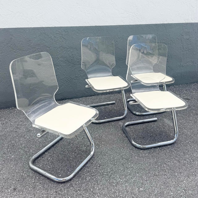 A striking set of Mid Century Modern dining chairs by Hill Manufacturing featuring a sleek combination of transparent...