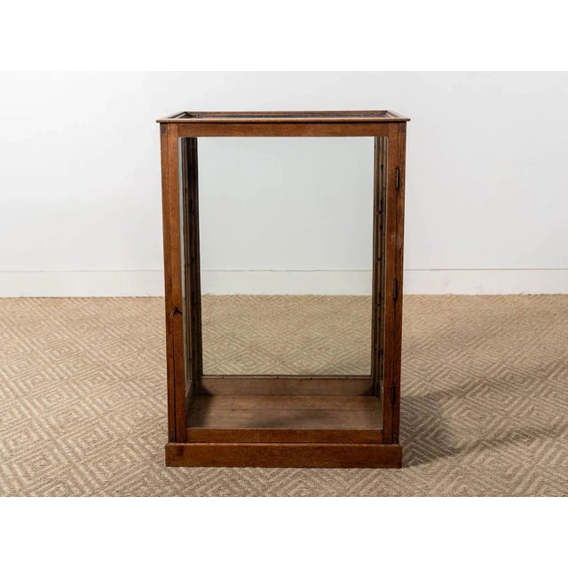 Glass and oak wood framed vitrine with brass hardware and lock and key detail. France Circa 1900