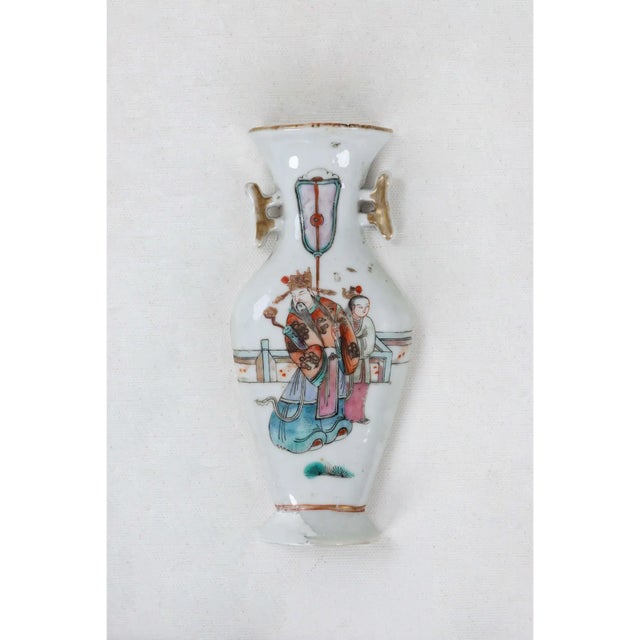 This flat backed porcelain vase can be hung on a wall as a decorative display while still being able to hold plants. Some...
