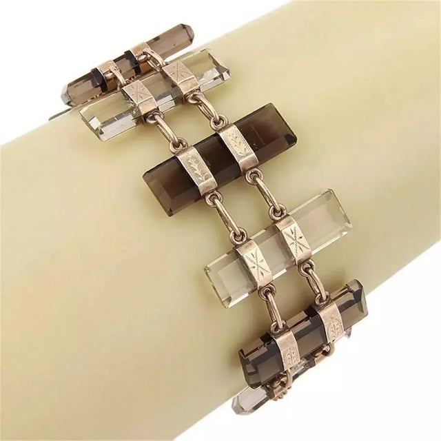 This is a gorgeous vintage bracelet. It has 9 long slim bars carved from smoky and clear quartz, each bar is held in...