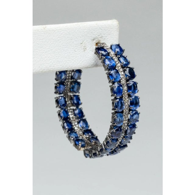 An amazing pair of hoops with a double row of faceted, oval kyanite gemstones with a double row of of round, brilliant cut...