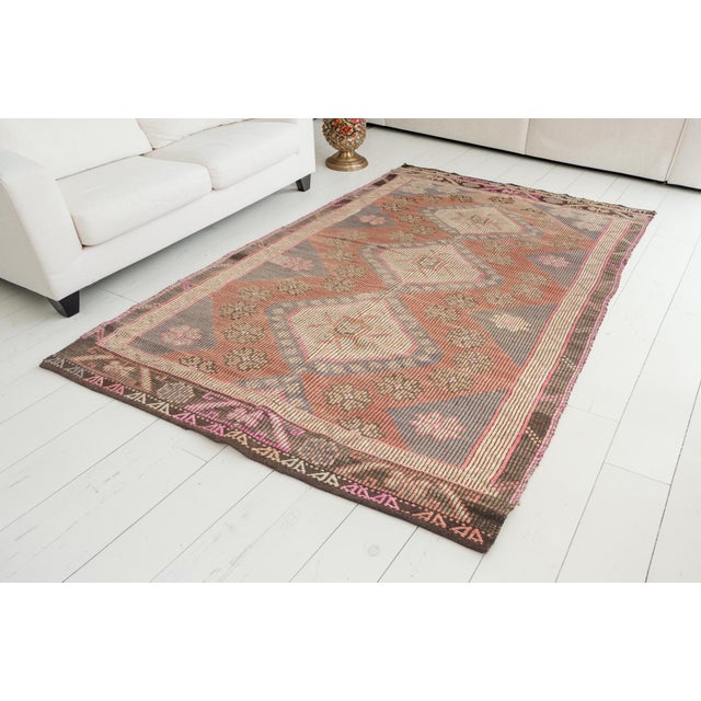 This is a vintage Turkish Oushak rug from the Mid 20th Century. The piece was hand-knotted.