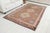 This is a vintage Turkish Oushak rug from the Mid 20th Century. The piece was hand-knotted.