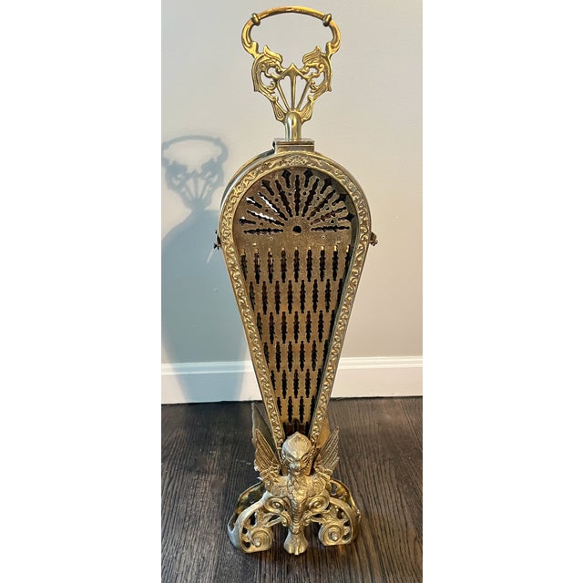A classic Hollywood Regency fire screen. Has 9 fenestrated brass ‘peacock feathers’ that fan out from the center. The...