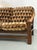 A three-seat sofa built around a sculpted solid wood frame, with leather arm straps adding a tailored, saddlery-like...