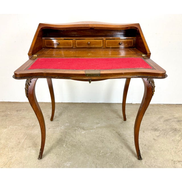 A fine and very well made Ladies writing desk in Louis XV style with highly detailed marquetry in exotic woods with bronze...