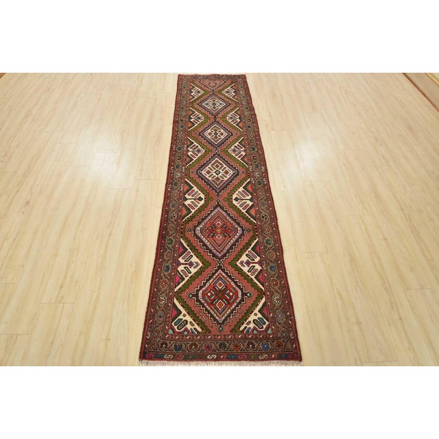 An authentic vintage tribal Hamedan runner hand-knotted with fine wool and natural dyes. This nomadic rug features a row...