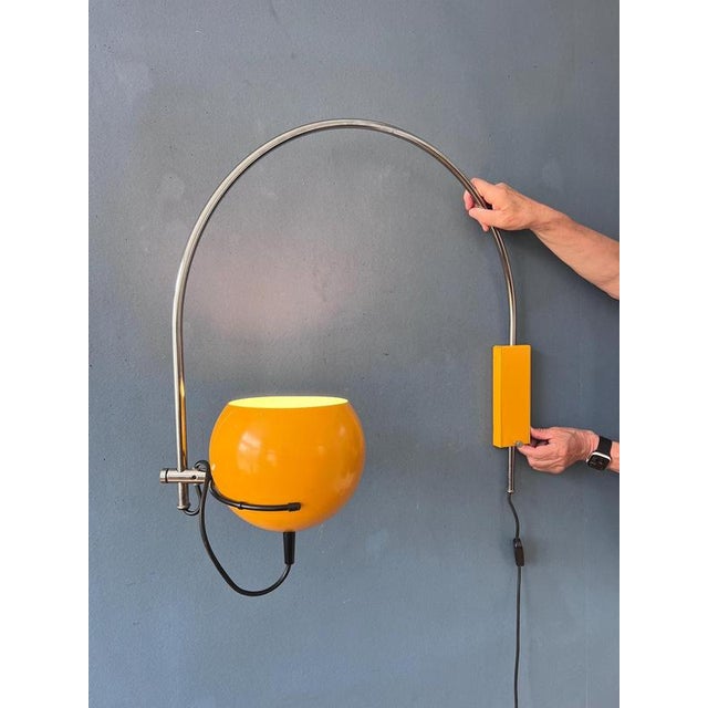 A classic arc wall lamp with yellow eyeball shade from the Dutch brand Herda. The shade can be turned in any direction...
