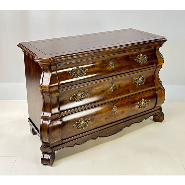 A beautiful vintage French Provincial style bombé chest or commode produced by Henredon Furniture Industries in Morganton,...