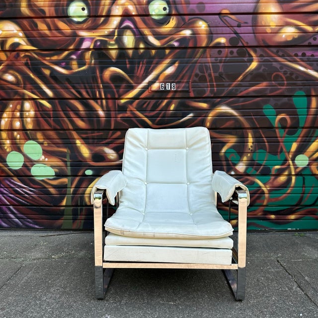 A stunning, vintage white glider chair in the style of Milo Baughman. This chair is covered in a nice white leather and...