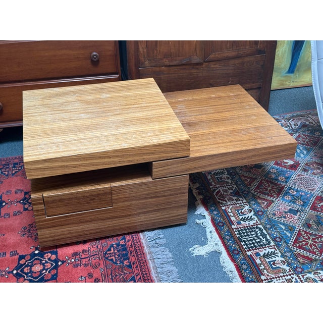 Design Plus Gallery presents a Multi-Tiered Wood Block Coffee Table + Drawer. The square coffee table has a cut-out that...