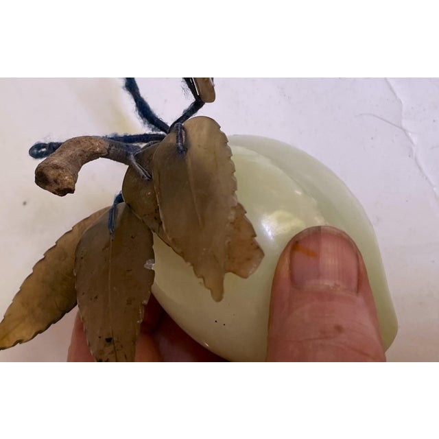 This is a sweet carved hard stone fruit, I'm not sure whether it's a green plumb or peach? It has carved stone leaves but...