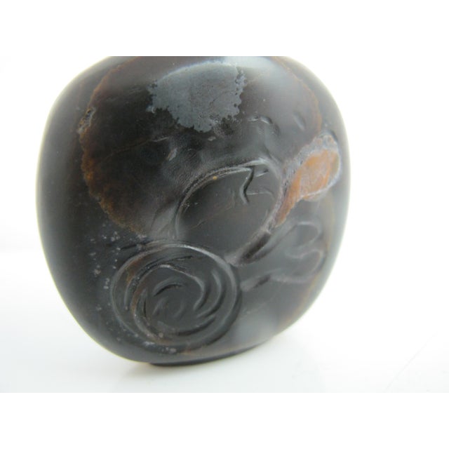 Chinese snuff bottle in tiger eye with flowery carving at front and pale jade green tone stopper. The carving is a bit...