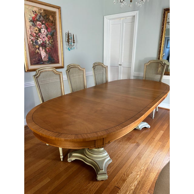 Elegant vintage nine-piece dining set featuring an oval satinwood extension dining table with 8 coordinating cane back...