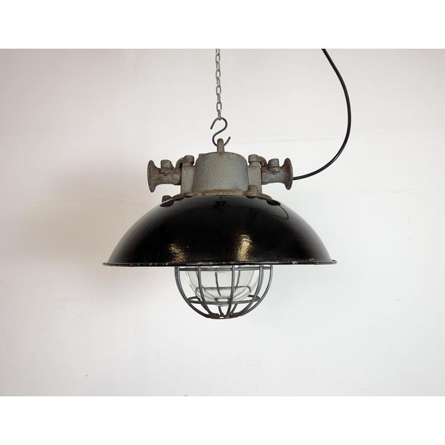 Industrial hanging lamp manufactured by Elektrosvit in former Czechoslovakia during the 1960s. It features a black enamel...