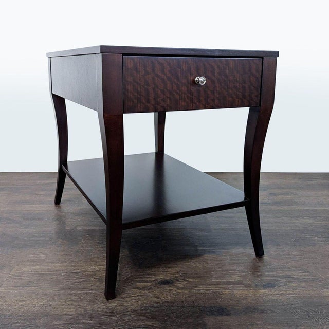 Elegant saber legs support a functional front drawer and shelf. The table is constructed from mozambique and mahogany...