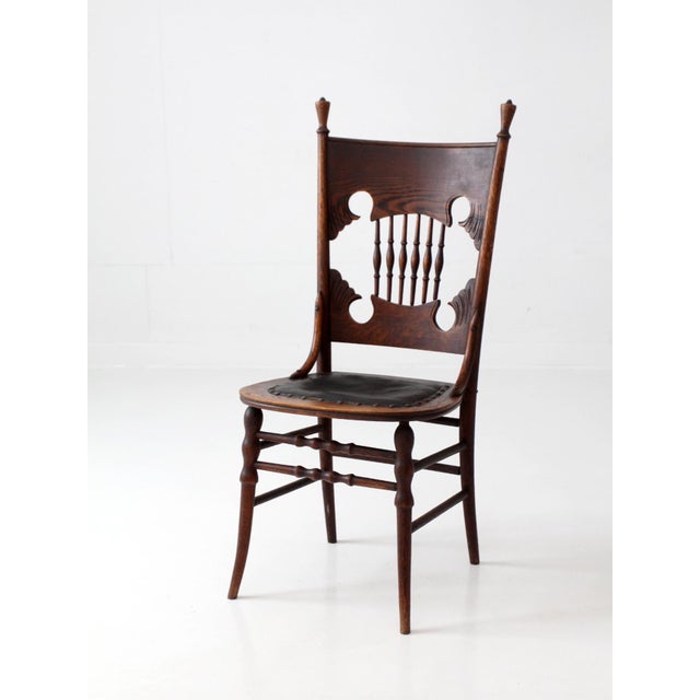 Antique Eastlake oak side chair dating to the late 19th century, featuring a sculptural back with turned spindles, carved...