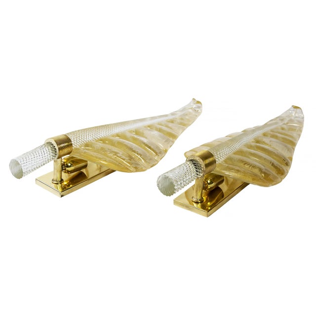 Pair of vintage Italian wall light sconces made of brass base decorated with handmade Murano glass leaves. Murano glass is...