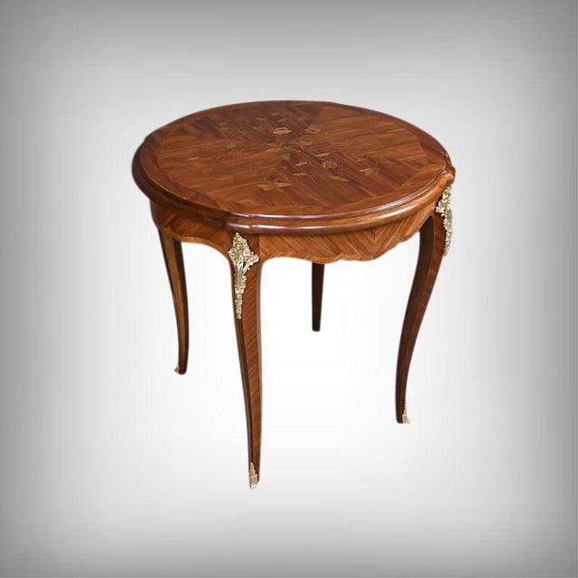 This Louis XV style salon table captivates with the elegance of its marquetry top, adorned with a delicate floral design...