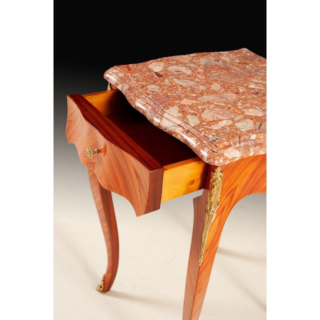 Handcrafted in Italy, this elegant accent table features a shaped marble top with warm natural tones and unique veining....