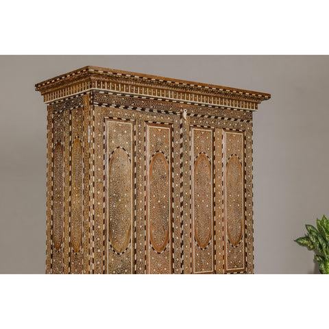 An Anglo-Indian style inlaid mango wood wardrobe cabinet from the mid-20th century, with floral themed bone inlay. This...