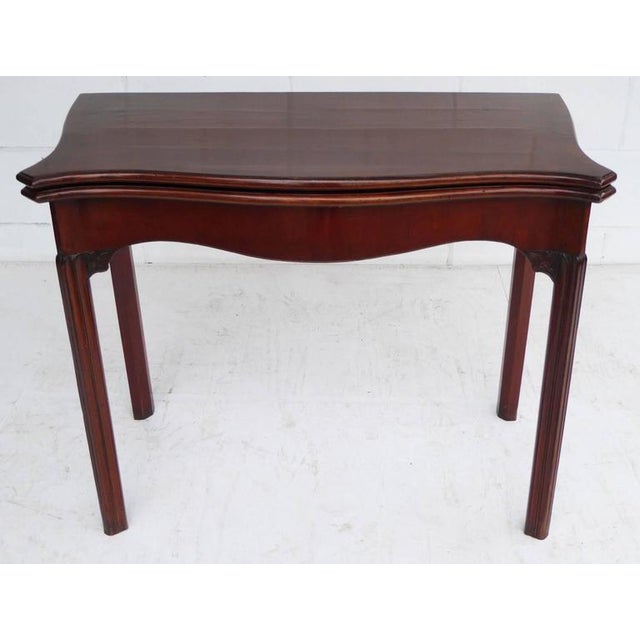 A good quality early George III mahogany serpentine cad table. The top of the table folds over to reveal a shaped green...