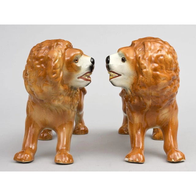 Pair of Staffordshire style lions with orangy brown body, black noses and glass eyes.