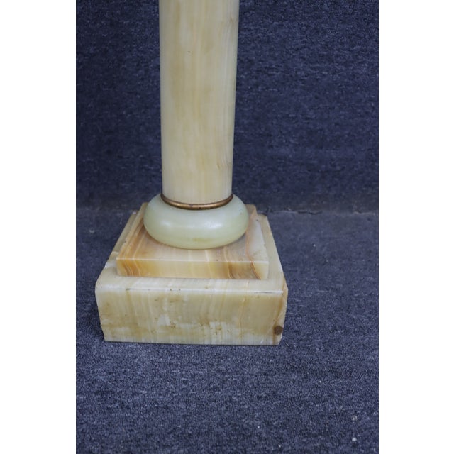 Elegant Neoclassical-style pedestal crafted in richly banded honey and cream onyx. The column form rises from a stepped...