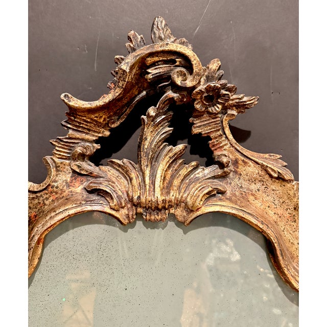 An exceptional and highly decorative Italian Rococo mirror featuring an elegant, dynamically sculpted design. This...