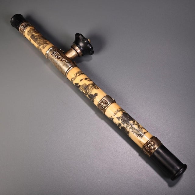 This is an antique opium pipe, a traditional smoking implement featuring a long, carved bone or ivory-colored shaft. The...